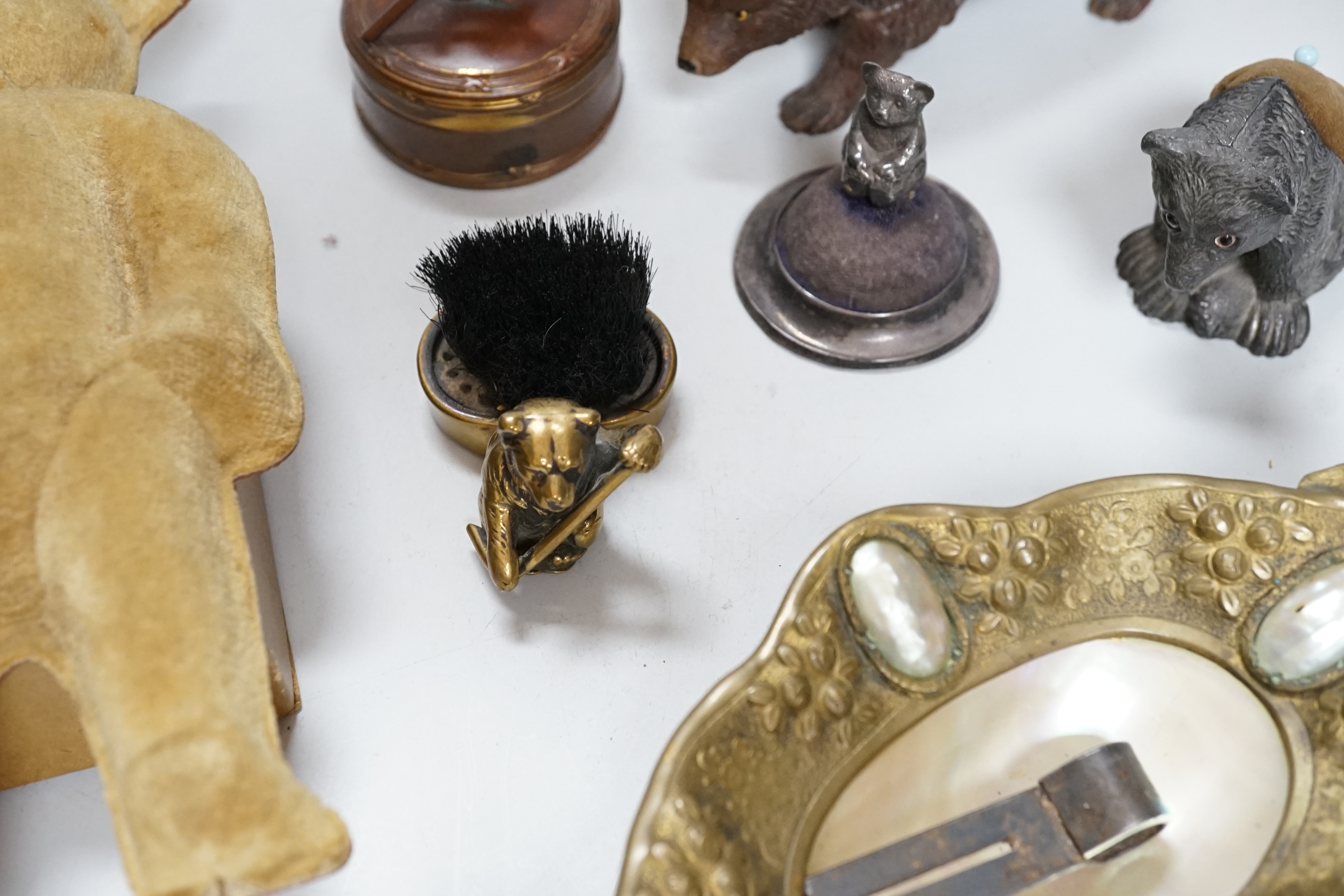 Four metal bear pin cushions, a money box, a bear stud box, three metal bears, a mother of pearl metal bear dish and an advertising bear on a box